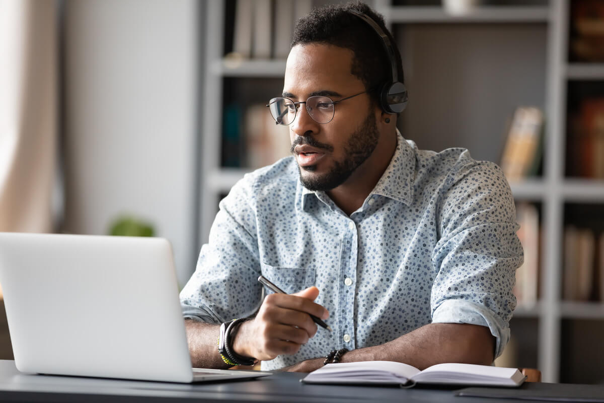 Male teacher on laptop with headphones