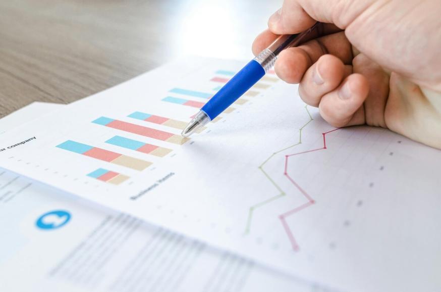 A person with a pen in their hand reviewing data. 