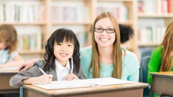 girl and teacher at desk 