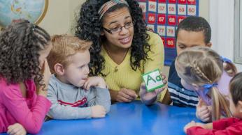 teacher showing letter A to preschoolers