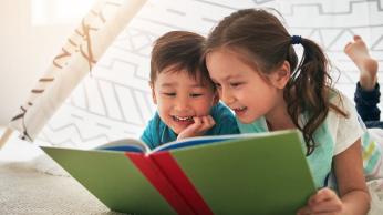 Boy and girl reading a book together.