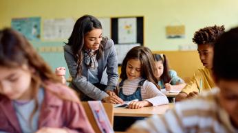 Teacher helping student in class.