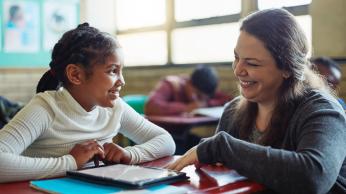 Teacher helping student one on one.