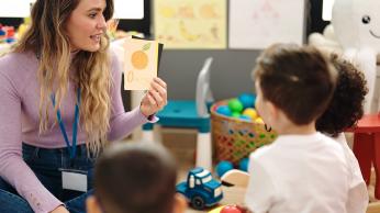 Teacher showing flashcards to students.