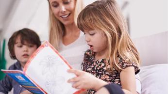 Children Reading Book with Educator