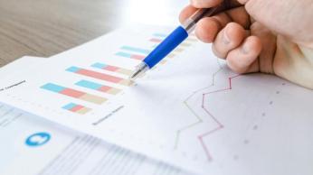 A person with a pen in their hand reviewing data. 