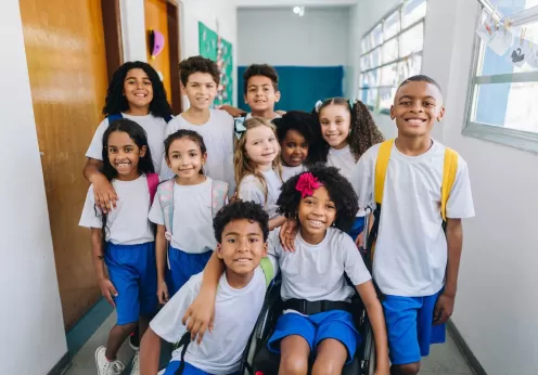 Multiple children posing together in a school hallway.
