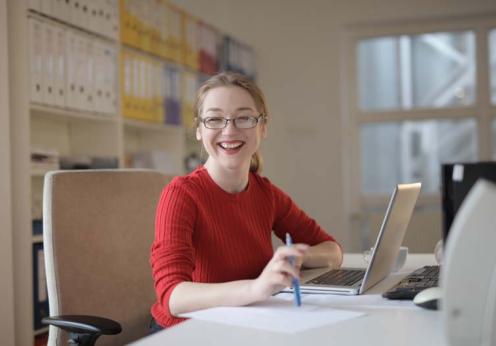 woman-in-red-sweater-leaning-on-white-table