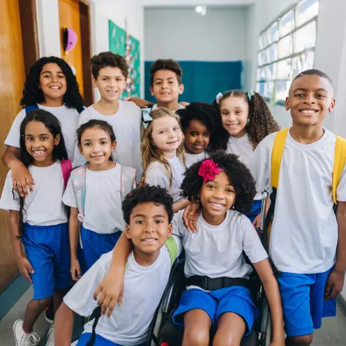Multiple children posing together in a school hallway.
