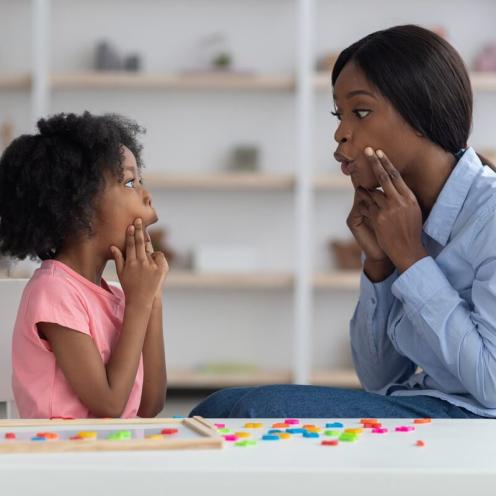 Woman and young girl practicing oral language.
