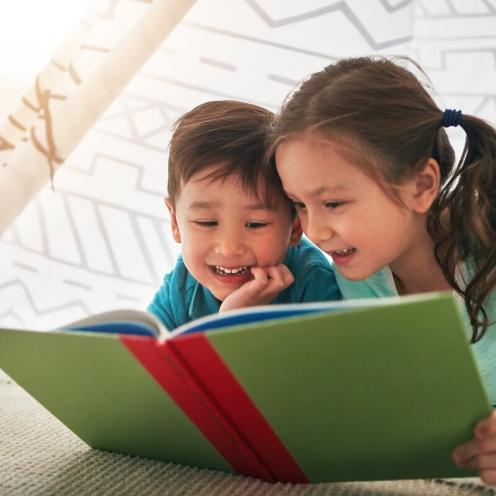Boy and girl reading a book together.