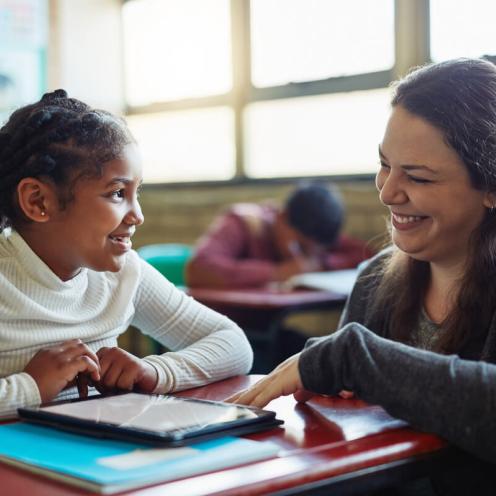 Teacher helping student one on one.