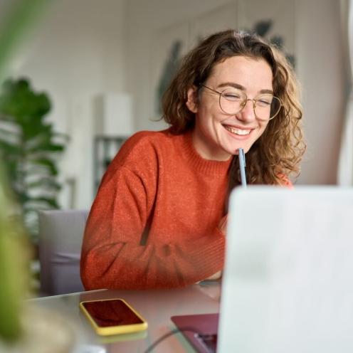 Woman smiling on laptop.