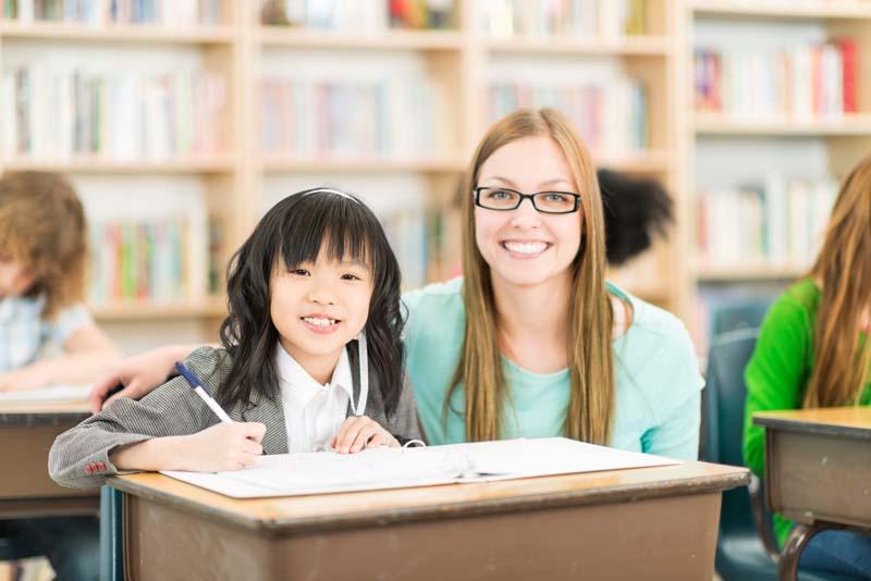 girl and teacher at desk