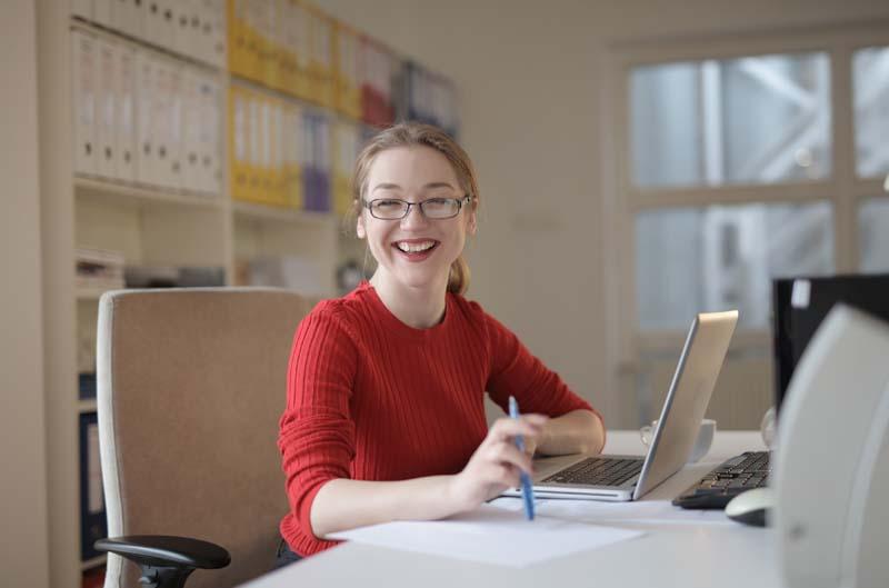 woman-in-red-sweater-leaning-on-white-table