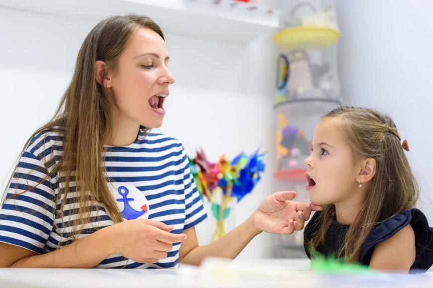 Woman and young girl practicing oral language.
