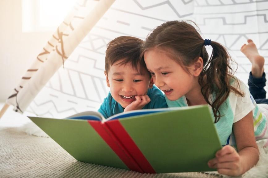 Boy and girl reading a book together.