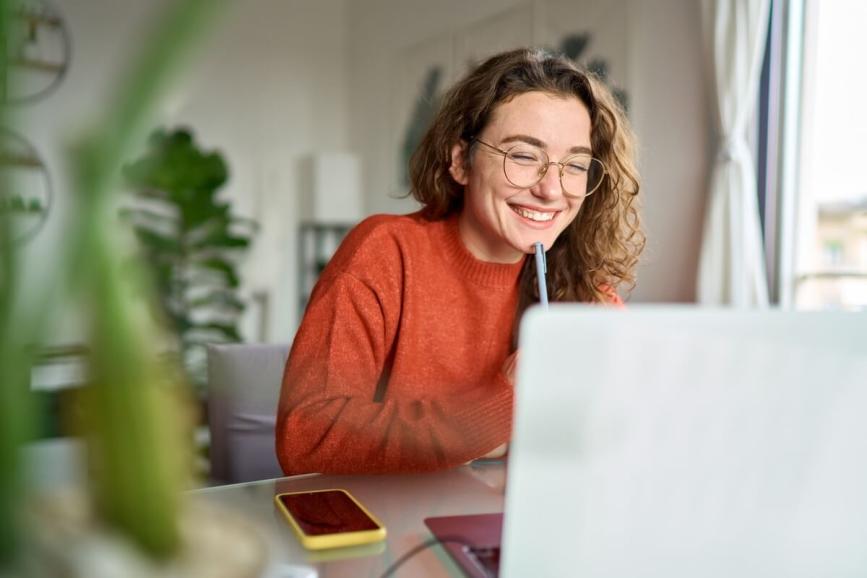 Woman smiling on laptop.