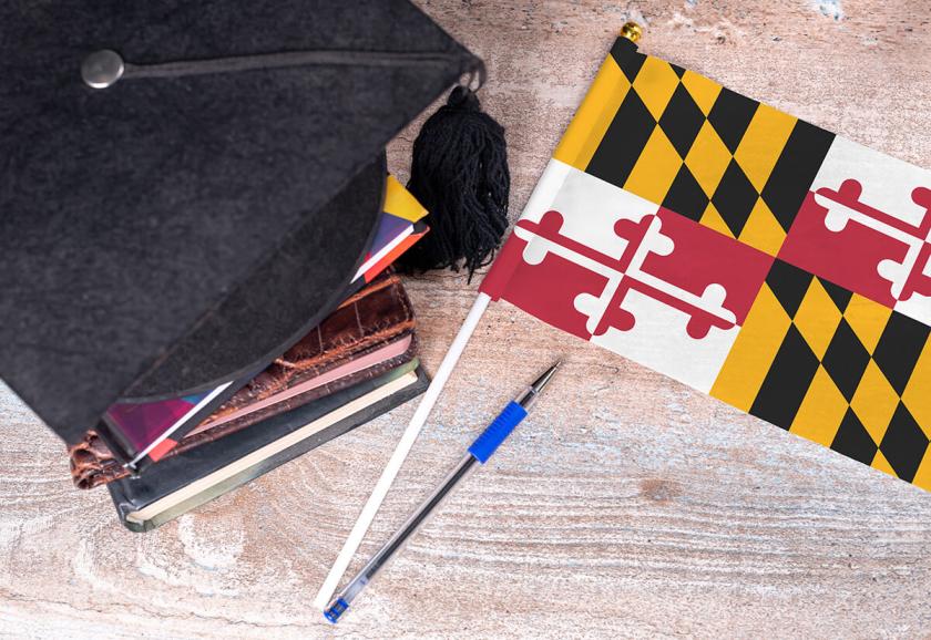 Maryland state flag and graduation cap sitting on books.