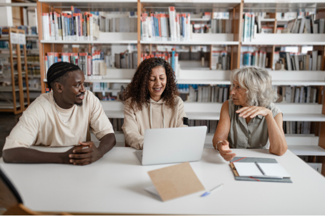 Three people collaborating in a library 