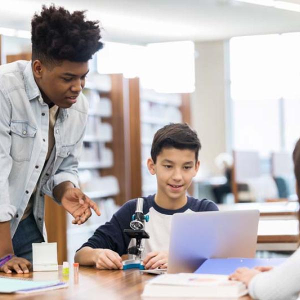 teach and student in library with laptop