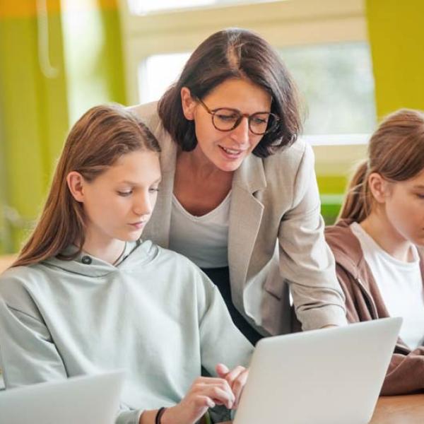 teacher with student at laptop