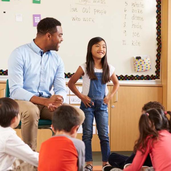 teach and kid in front of class