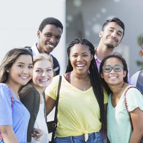 older kids smiling out front of school
